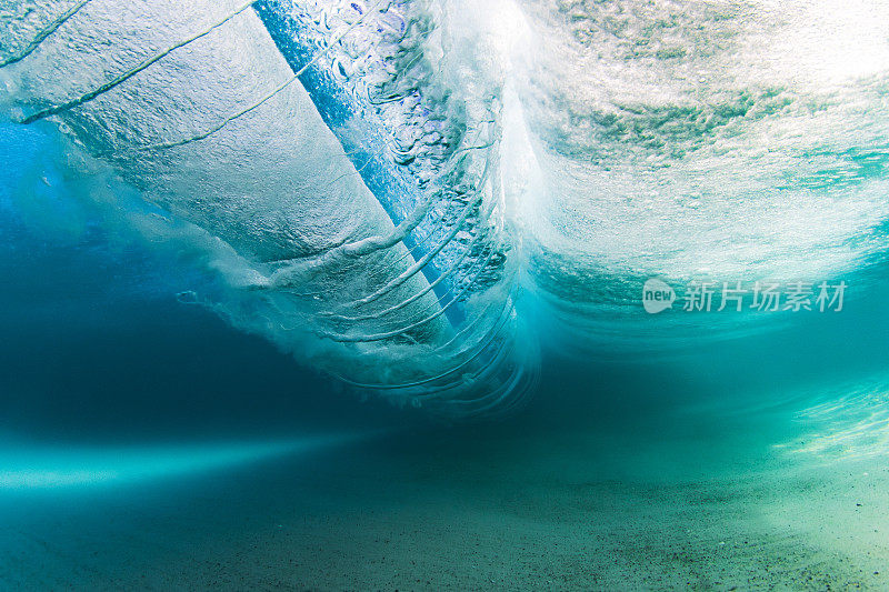 在清澈的海水中，海浪拍打着沙滩，水下的景色一览无余