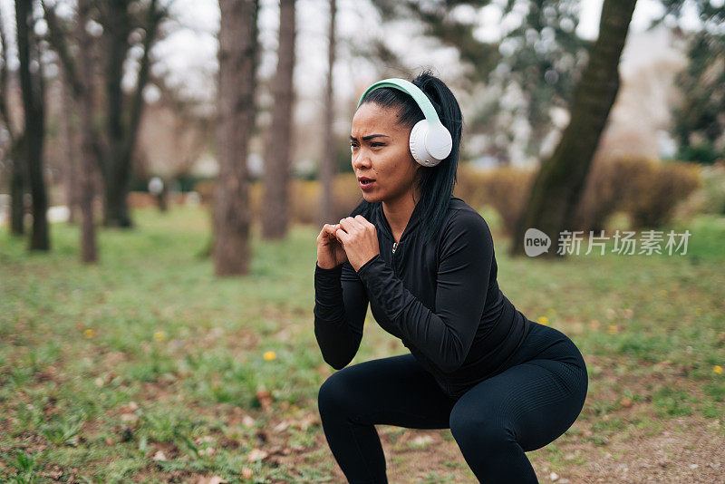 一位健身妇女正在公园里训练。