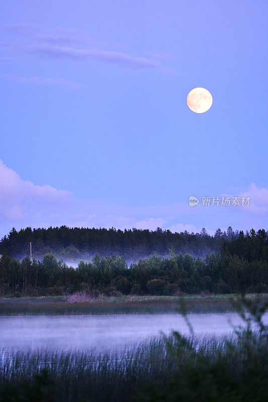 黄昏时分，月光照在乡村风景优美的湖面上