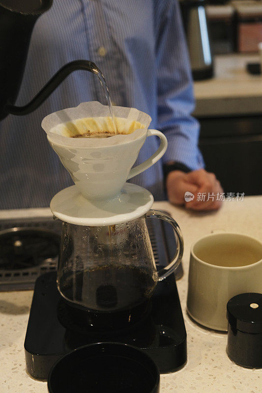 无法辨认的咖啡师将热水倒入咖啡滴滤