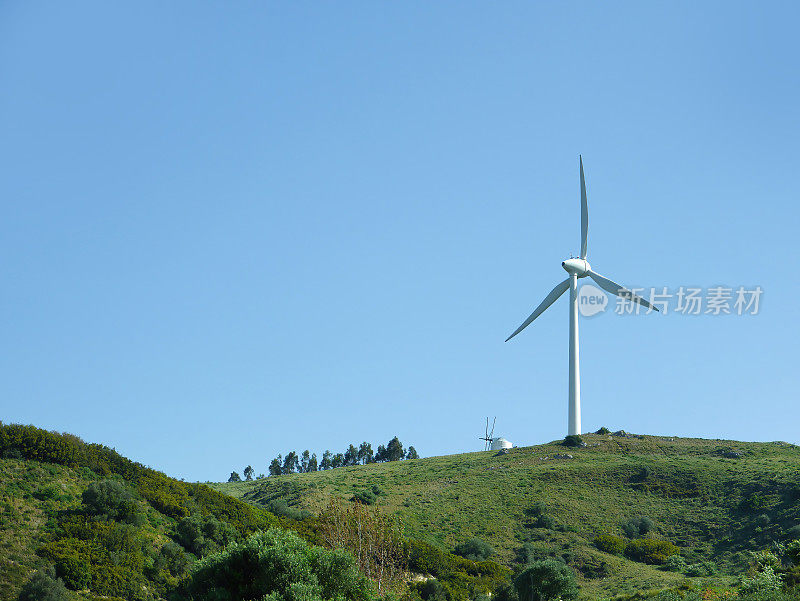 可持续的生态能源理念。绿色山顶上的现代风力涡轮机，产生清洁可再生和无污染的能源农场，风车发电机