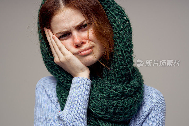 女人在她头上织围巾，健康问题流鼻涕的蓝色毛衣