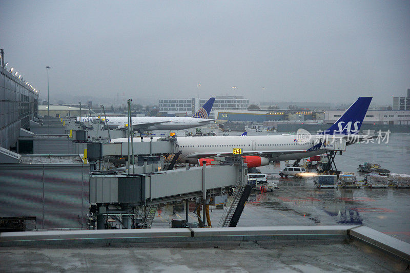 两架长途飞机在下雨天停在旧金山国际机场门口