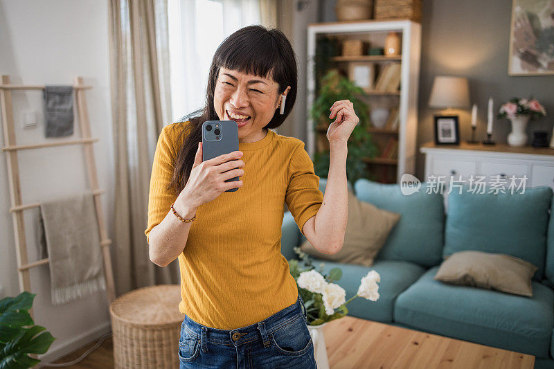 一位年轻漂亮的人字拖女沉浸在自己的音乐世界里，通过无线耳机听着自己最喜欢的歌曲。