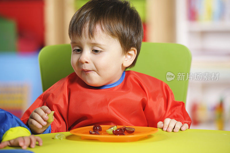 幼童在用餐时间吃葡萄结束