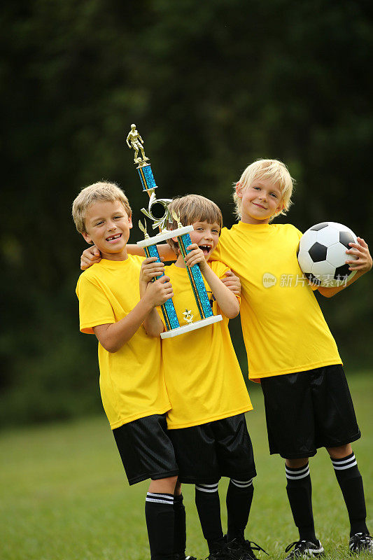 男孩足球队拿着奖杯
