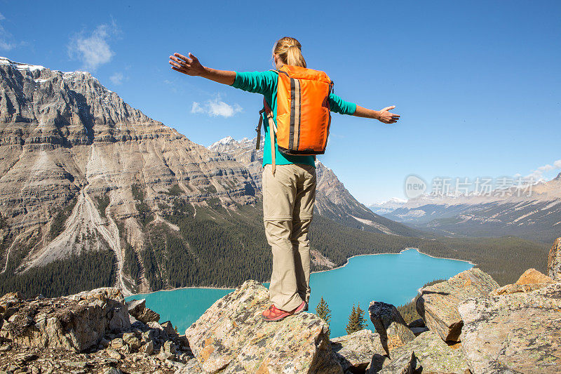 在山顶上欢呼的登山运动员张开双臂