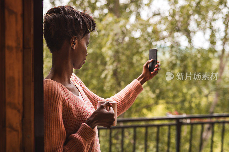 一位年轻的非裔美国女性正在用手机自拍。