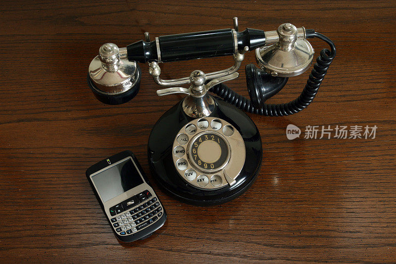 木头背景上的旧电话和新手机