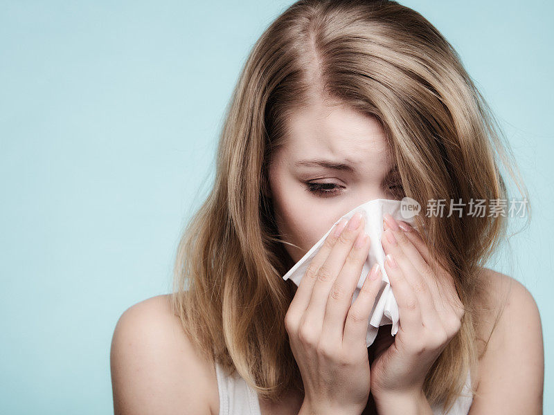 流感过敏。生病的女孩用纸巾打喷嚏。健康