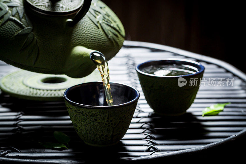香喷喷的凉茶，茶壶放在黑色的桌子上