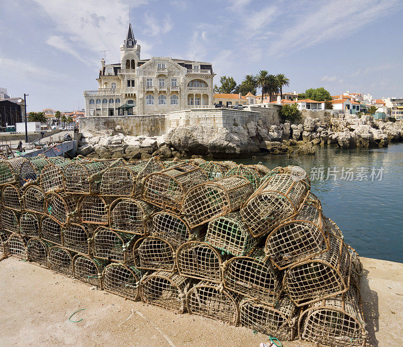 水边堆着捕蟹笼，后面是古色古香的小镇
