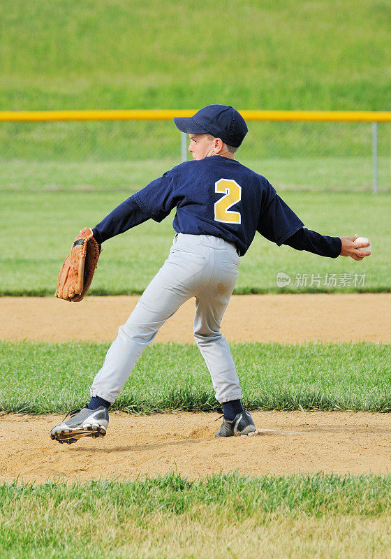 年轻男运动员在棒球场投球