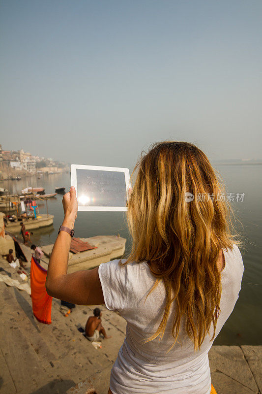 年轻女子用平板电脑拍照