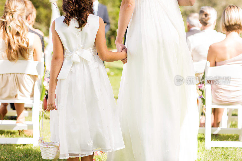 新娘和花童在花园婚礼中手牵手