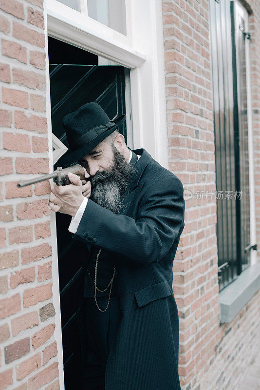 长胡子男子用步枪沿着前门附近的墙射击。