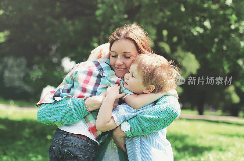 夏日里，快乐微笑的母亲拥抱着孩子们