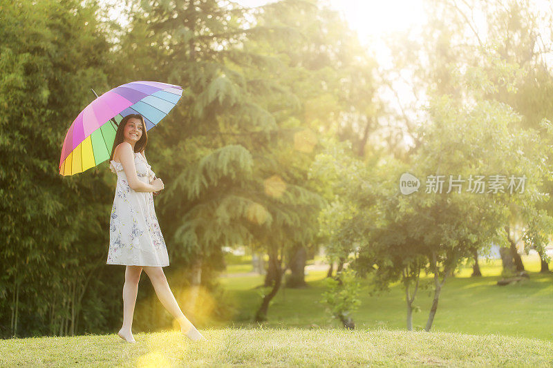 拿着白伞的女人站在田野里