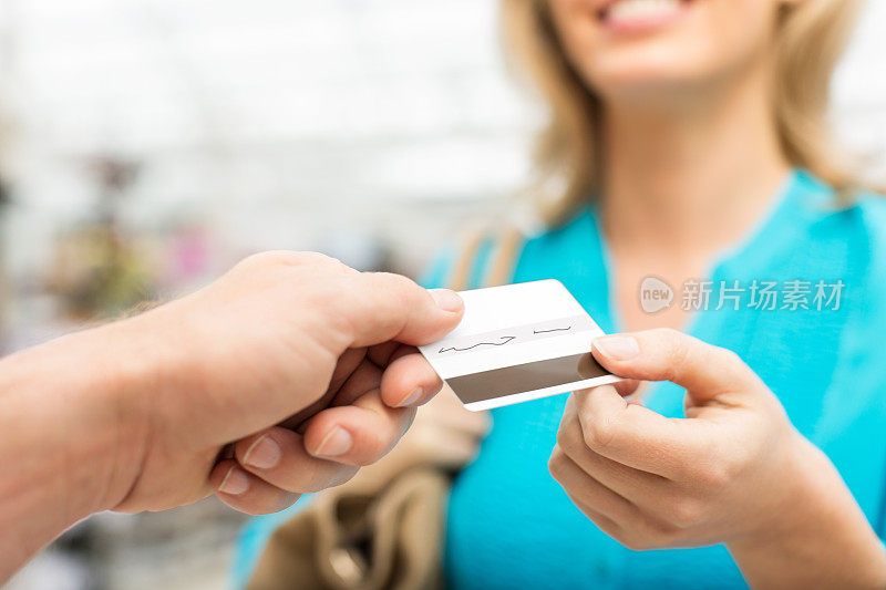 在商店里用信用卡的女人