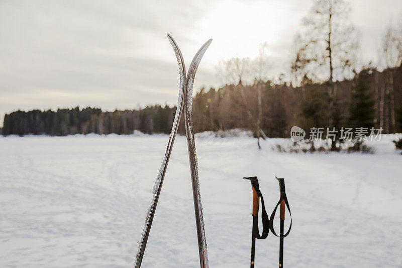 二月份在结冰的湖边滑雪和滑雪杖。