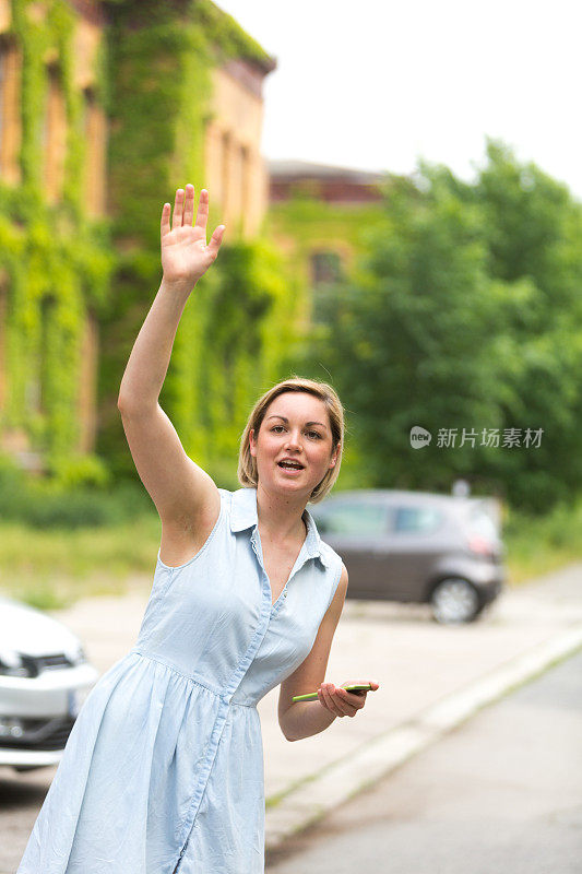 年轻女子拿着手机找出租车