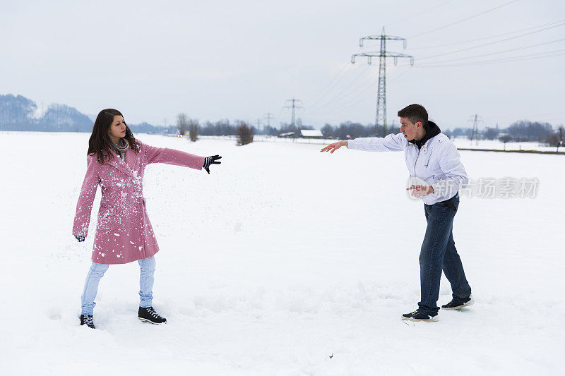 年轻人向他的女朋友扔雪球