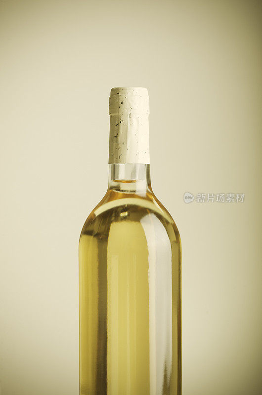 米色背景上的白酒瓶-垂直