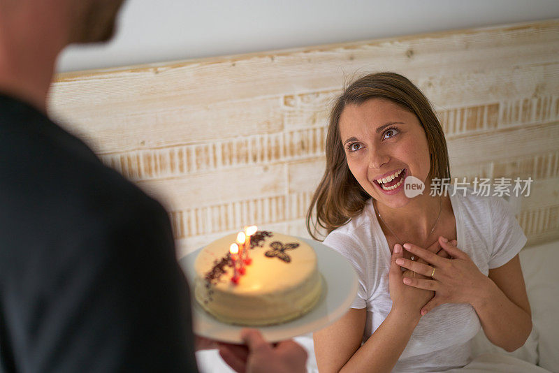 年轻女子在床上庆祝生日