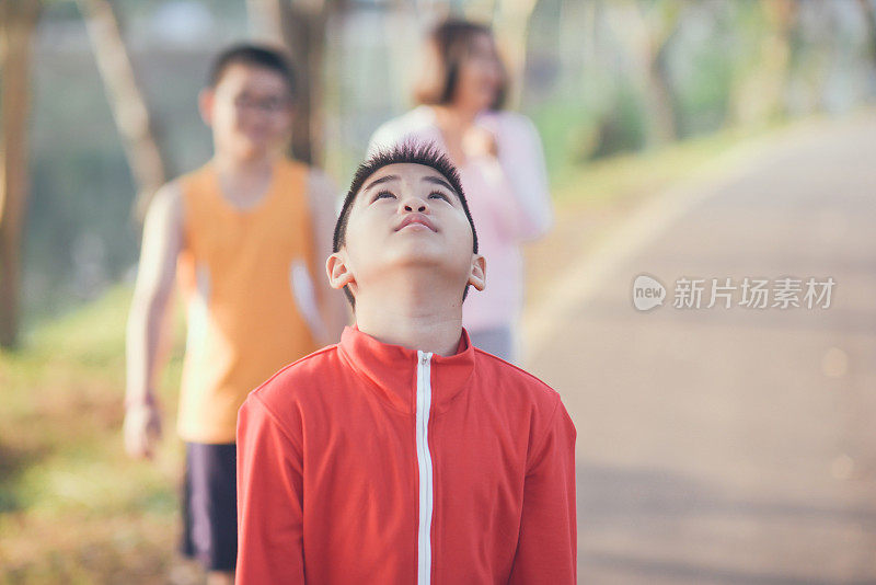 家庭运动快乐活跃的母亲和孩子在户外慢跑，在森林里跑步