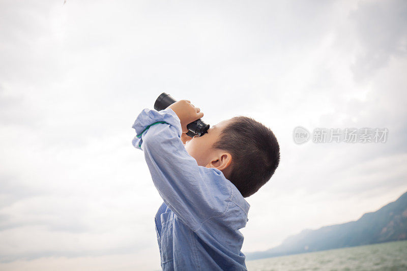 小男孩用望远镜看