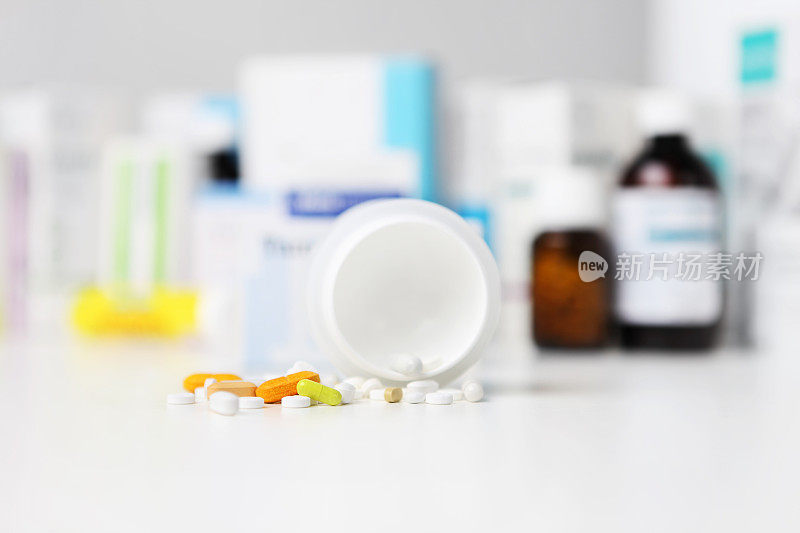 瓶子药丸和胶囊在桌子上，药物和药片盒在背景