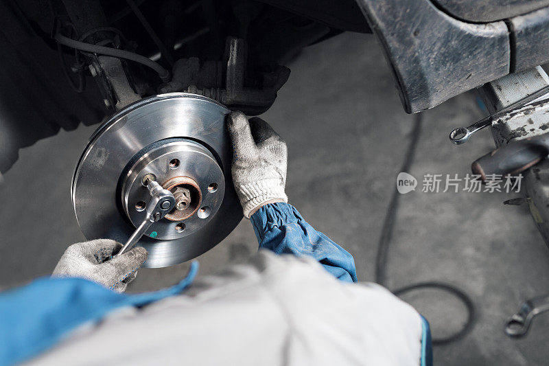 汽车修理工在车库里更换刹车。