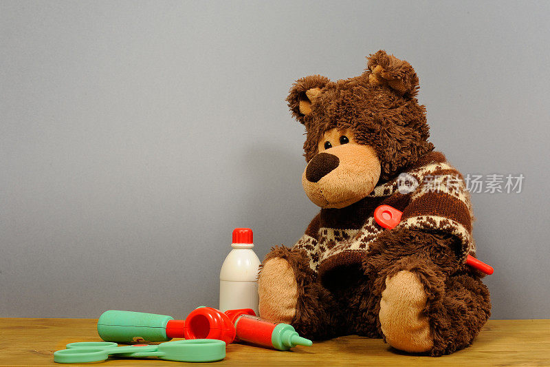 灰色背景上有头的泰迪熊。发烧和头痛的人。熊玩具病了。