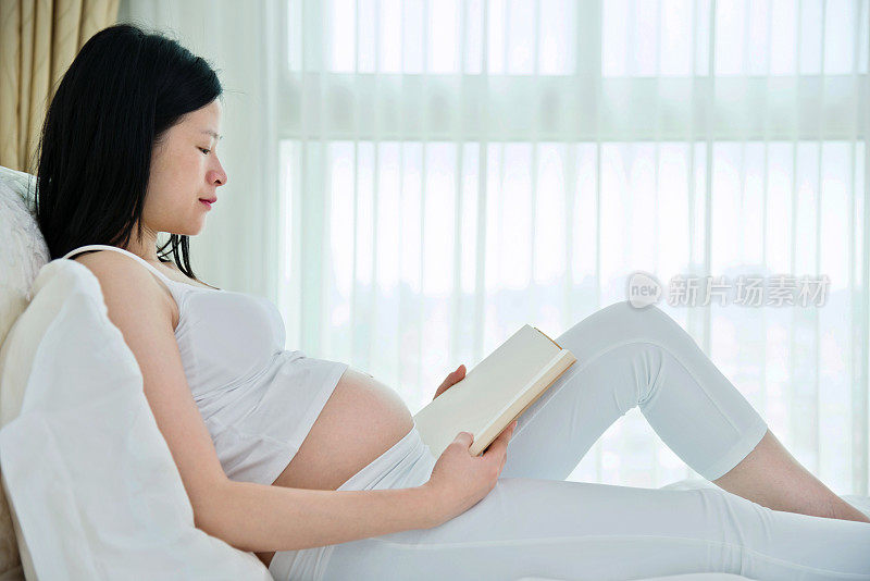 孕妇在床上看书