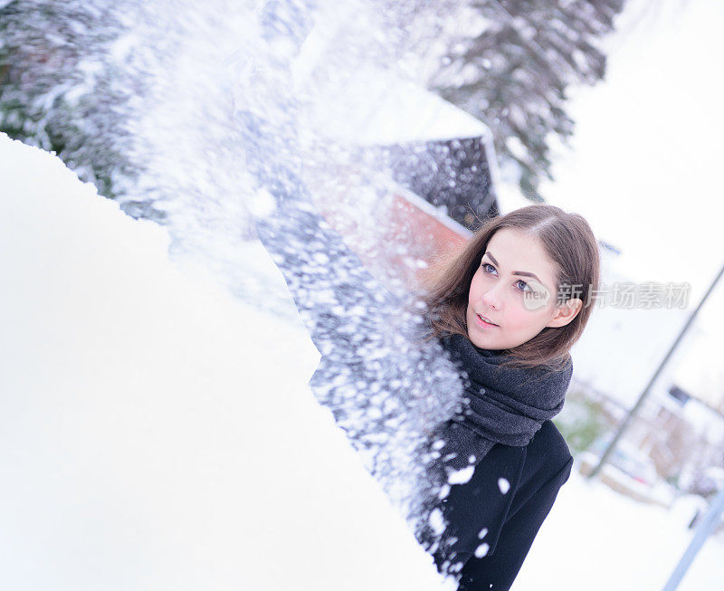 冬天即将来临。女人在冰冷的天气里，车被雪覆盖着。