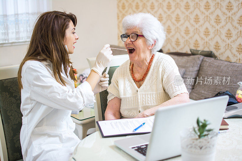 护士用棉签从一位老年病人的喉咙中提取样本。