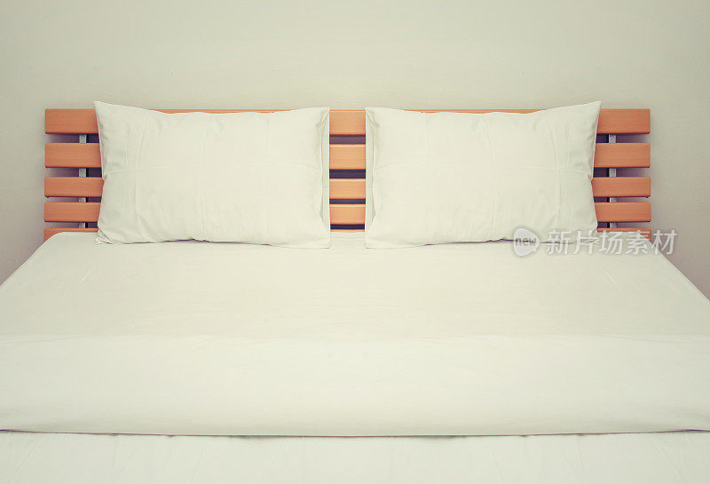 卧室的木床上有白色的毯子和枕头