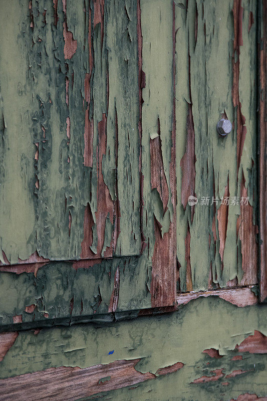 一扇旧门上的绿色油漆正在脱落