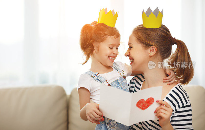 母亲节快乐!母亲和女儿戴着王冠，带着明信片