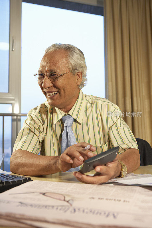 老年商务男子使用计算器