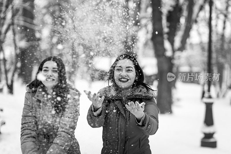 快乐的妈妈和女儿在雪中玩耍