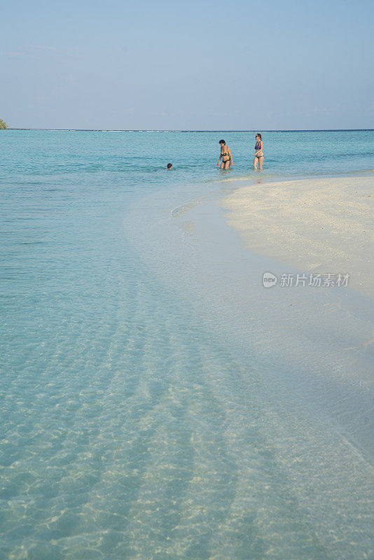 美丽的老年妇女走在水边的小岛屿海滩四月，马尔代夫