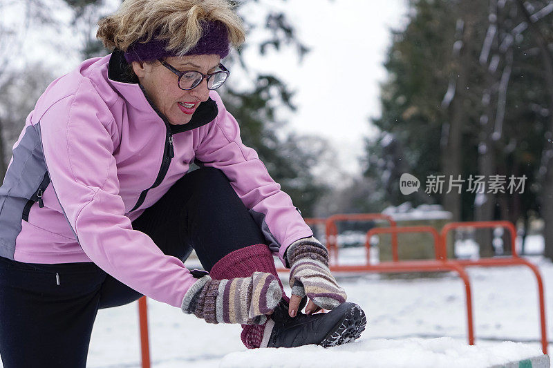 老年妇女在冬季在公园锻炼