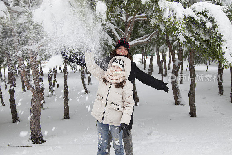 妈妈和女儿在雪中玩耍