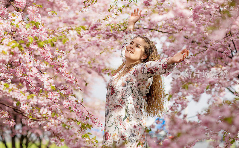 美丽的金发女人独自在樱花树