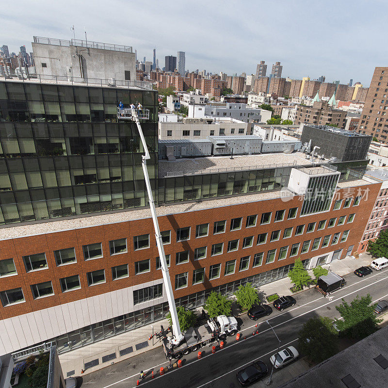 在纽约市哈莱姆区使用升降平台进行高空作业。高纬度的观点。