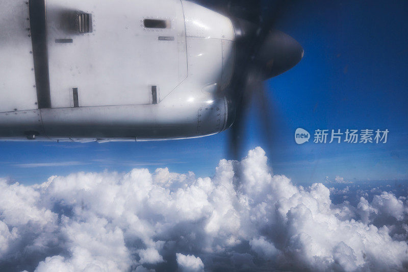望着飞机窗外的双引擎螺旋桨高高的云层