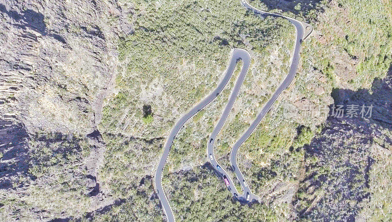 多风的道路横跨山脉，上方鸟瞰图在单色，向下指向无人机摄像头