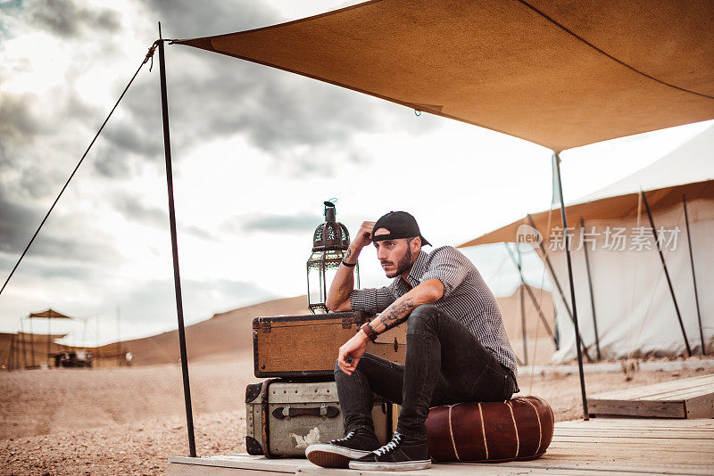 一个人坐在沙漠帐篷前