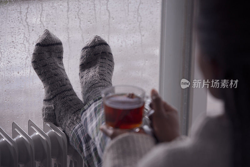 后面是一个女人在阴冷潮湿的天气在家喝茶的画面。